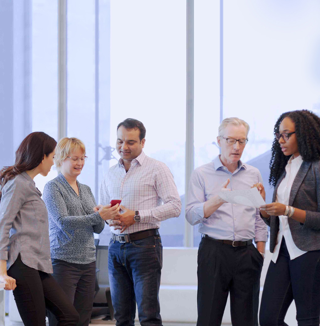 Groupe de collègues divers en conversation dans un bureau